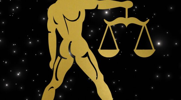 Graphic of a golden libra on a night sky background.